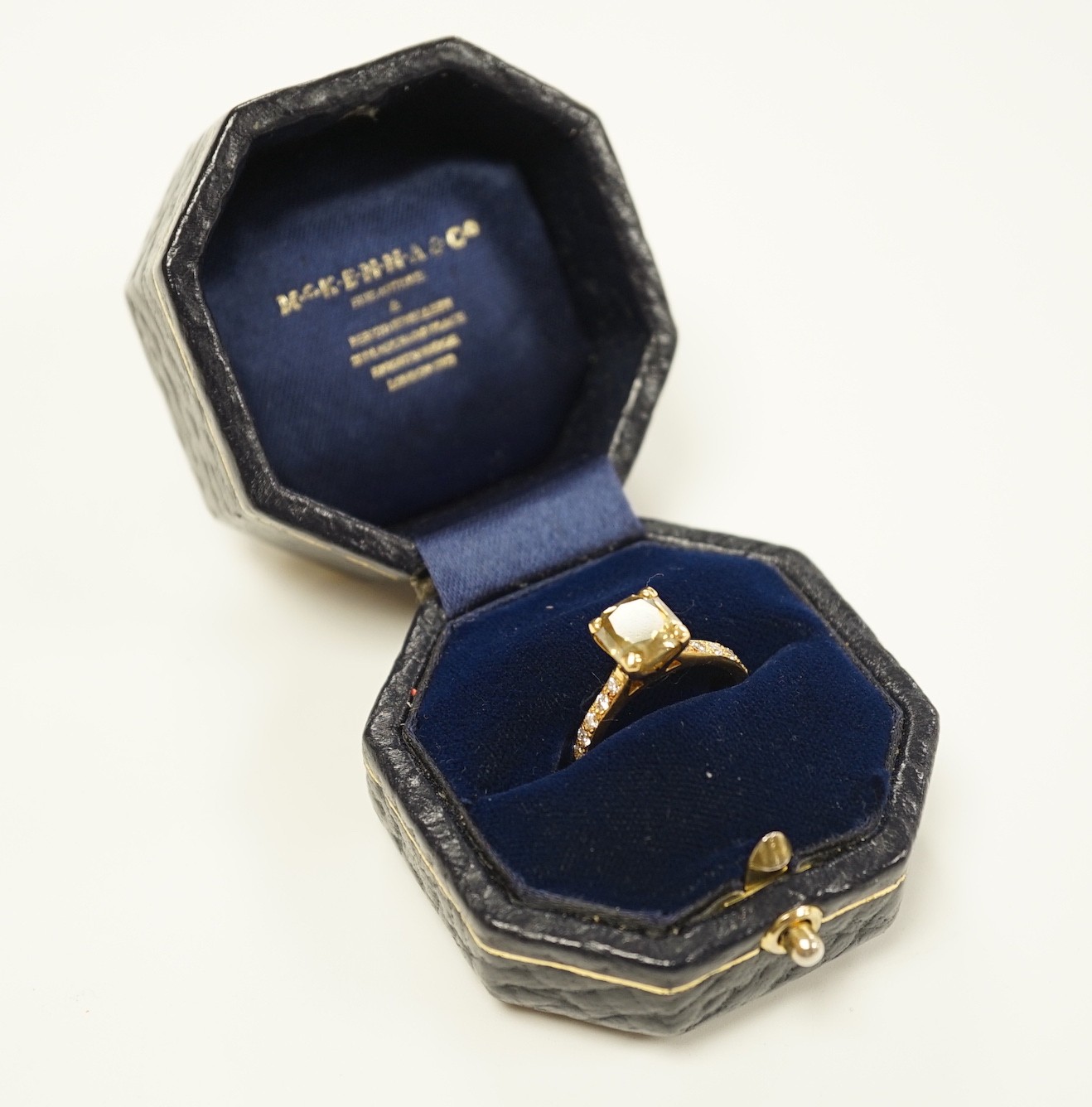 A modern 18ct gold and single stone cut cornered rectangular modified brilliant cut fancy dark brown-greenish yellow diamond, with diamond set shoulders and accompanying GIA report dated 20/12/2013, stating the stone to